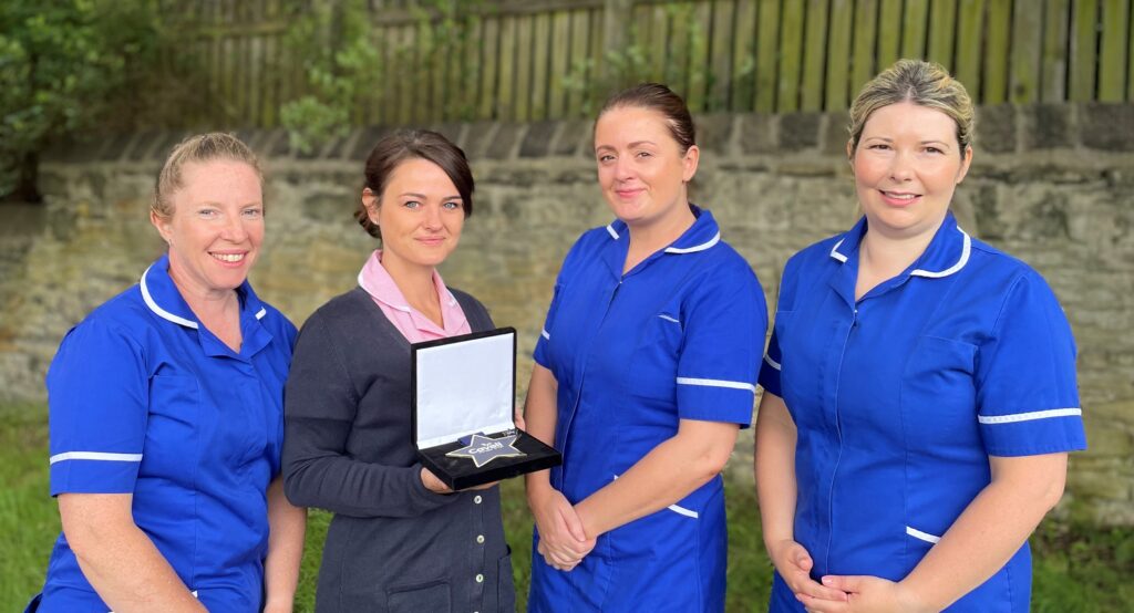 Micki with her award and colleagues