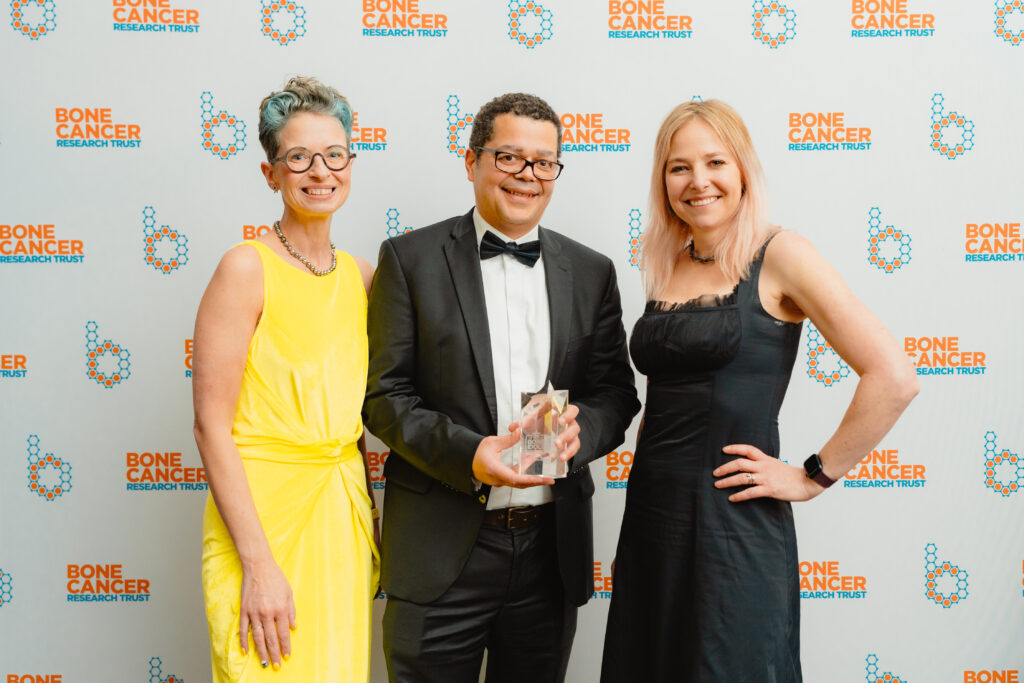Three people are standing together. On the left is Dr Liz O'Riordan, in the centre is Mr Kenny Rankin with his award and to the right is Professor Alice Roberts