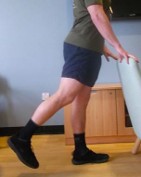 Person stood on one leg with one leg backward. They are holding onto a stable support. 