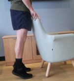 Person standing on their toes. They are holding onto something for support. 