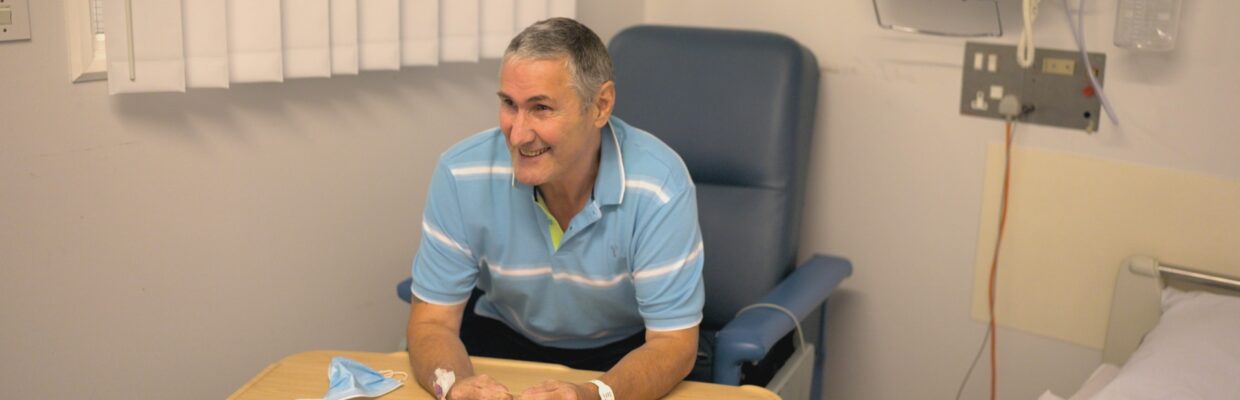 A patient sitting in a chair beside a hospital bed