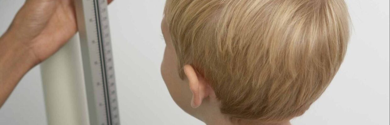 A young child having his height measured