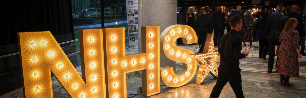 A light up sign of the NHS logo