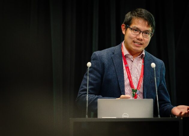 A photo of Dr Yi Ng speaking at a conference