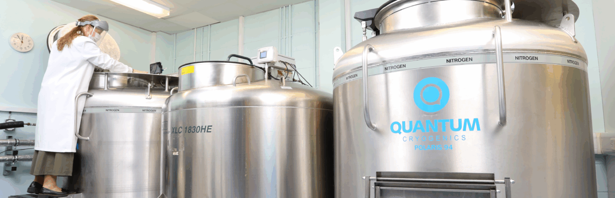 A scientist checks the contents of a large steel container