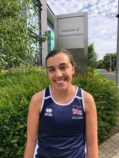 A woman in exercise clothing standing outside of the Institute of Transplantation