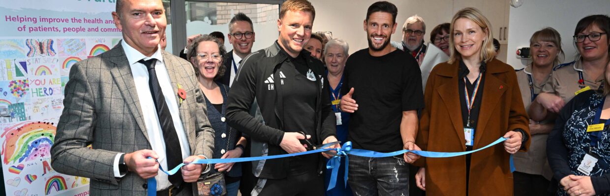 A group of people surrounding Eddie Howe cutting a blue ribbon into 'A new Haven'.