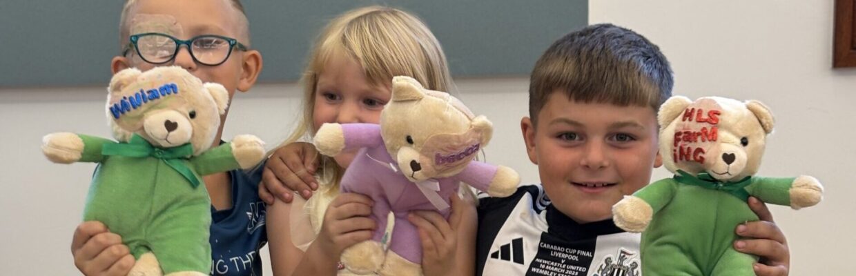 Three young children holding small bears