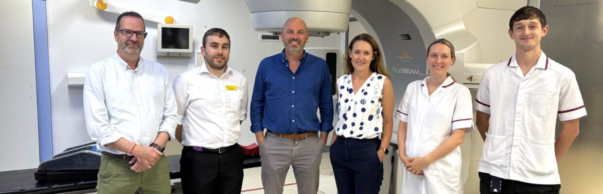 A group of people standing in front of a large medical machine