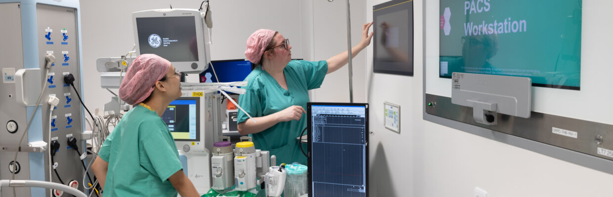 An image of surgeons in a theatre looking at something on a screen