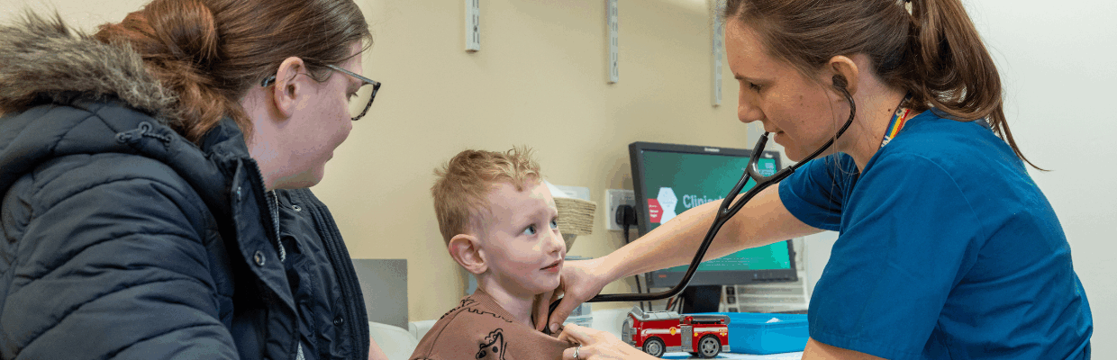 image shows a consultant listening to a young boys heart