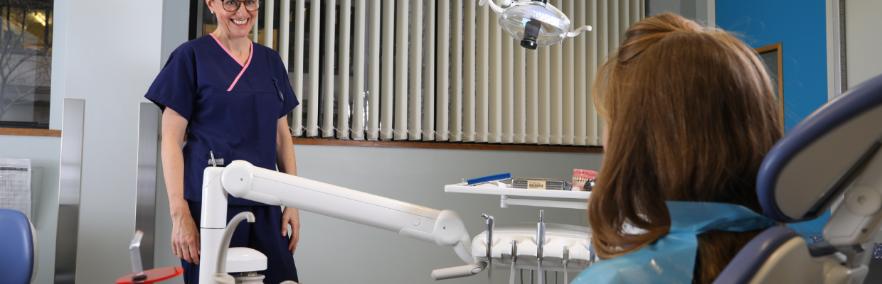 Dr Susan Bissett with a patient in a dental consultation room.