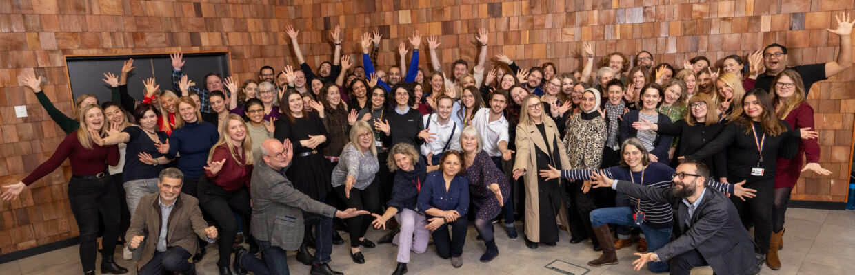 The John Walton Muscular Dystrophy centre team standing together with their hands in the air.