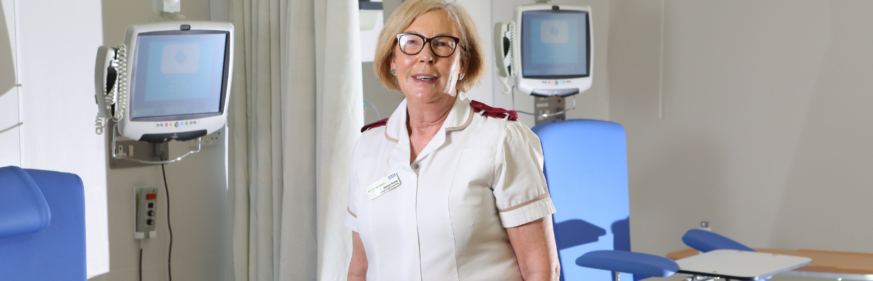 A clinical trials associate is pictured standing in a hospital bay